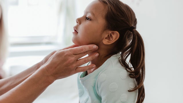 Cropped hands of doctor examining girl's throat in hospital 